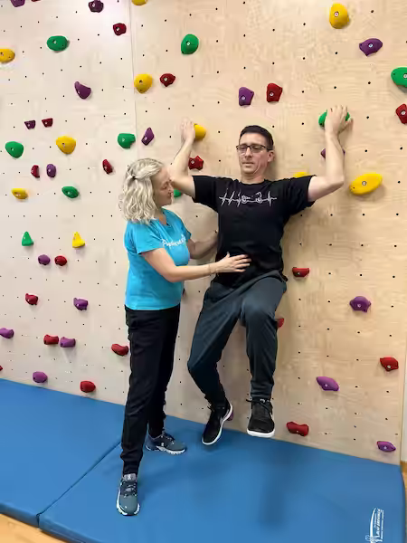 Physiotherapeutin Doris Schilling an der Kletterwand mit einem Patienten
